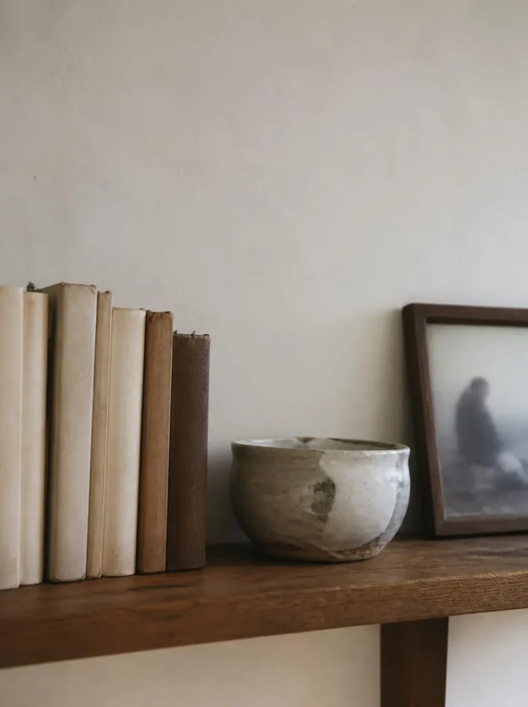 Simple shelf with meaningful books, pottery, and open space
